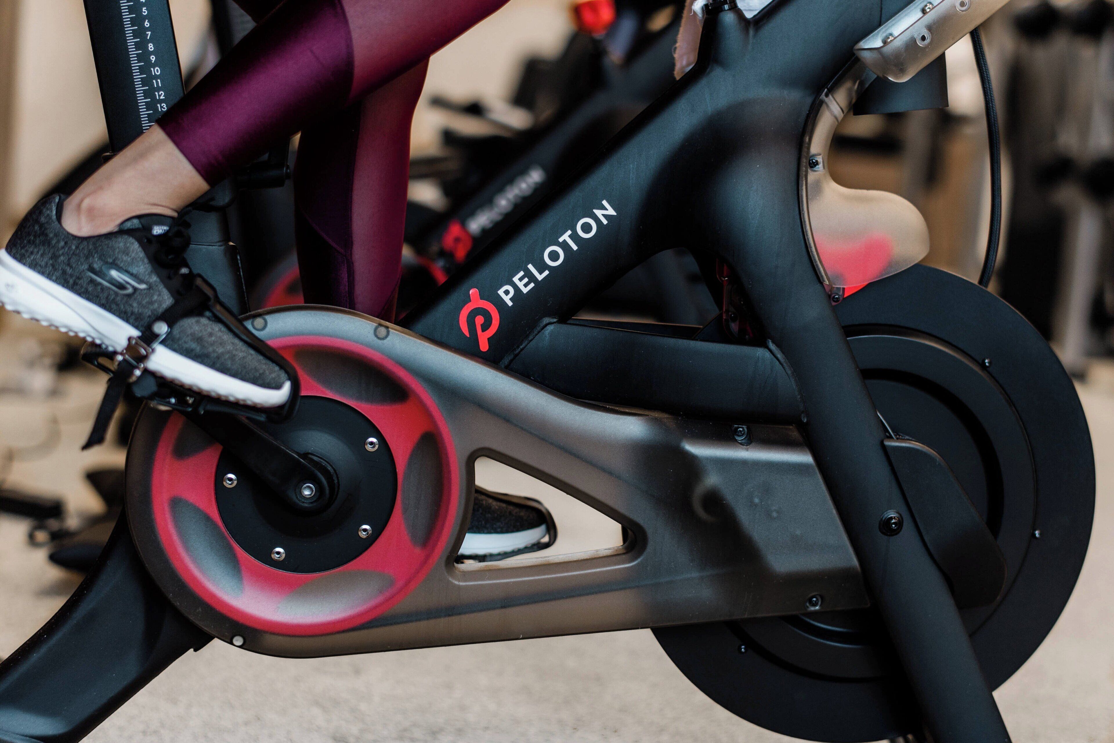 A Peloton stationary bike with a black and red color scheme.
