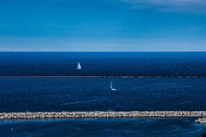 A coastal view with a rocky breakwater and a sailboat in the distance. - The Westin Milwaukee (Milwaukee)