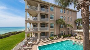A multi-story hotel with a pool area, outdoor seating, and a view of the ocean. - 3 by the Sea 3 Bedroom Holiday Home by Five Star Properties (Panama City Beach)