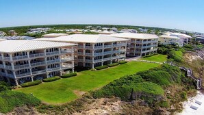 A multi-story hotel with balconies, a grassy lawn, and a beach view. - 3 by the Sea 3 Bedroom Holiday Home by Five Star Properties (Panama City Beach)