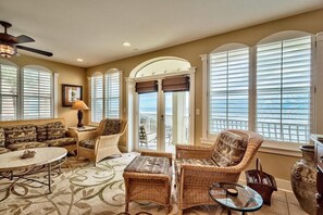 A spacious living room with a large window, a ceiling fan, and a view of the ocean. - 30A Monterey Place 3 Bd Holiday Home by Five Star Properties (Panama City Beach)