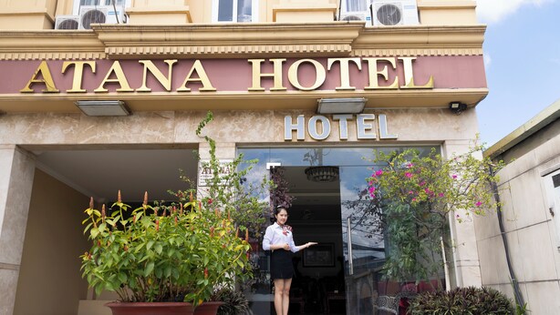 The entrance of Atana Hotel with a woman standing in front. - Atana Airport Hotel (Ho Chi Minh City)