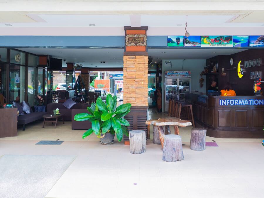 Un vestíbulo de hotel con mostrador de recepción, zona de estar y un letrero que dice 'Moon Travel'.