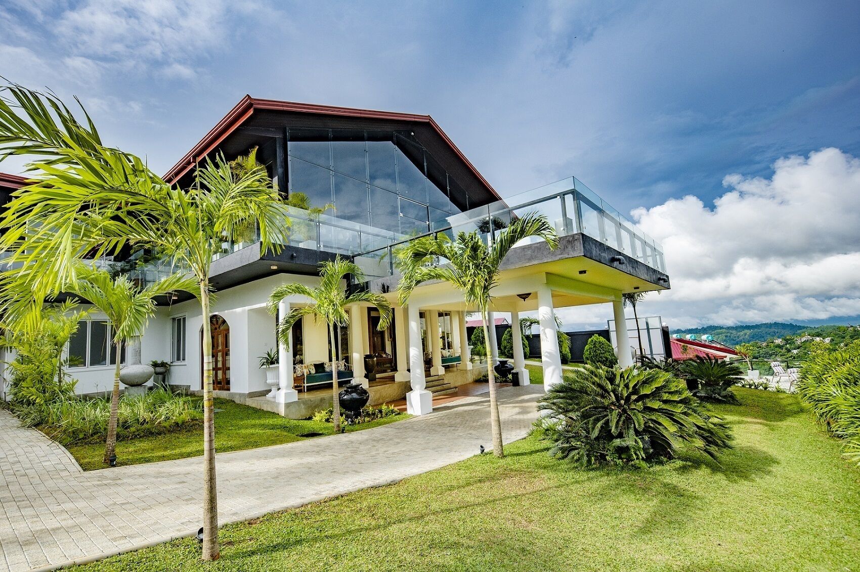 Ein modernes Haus mit Wintergarten, überdachter Terrasse und gepflegtem Garten.