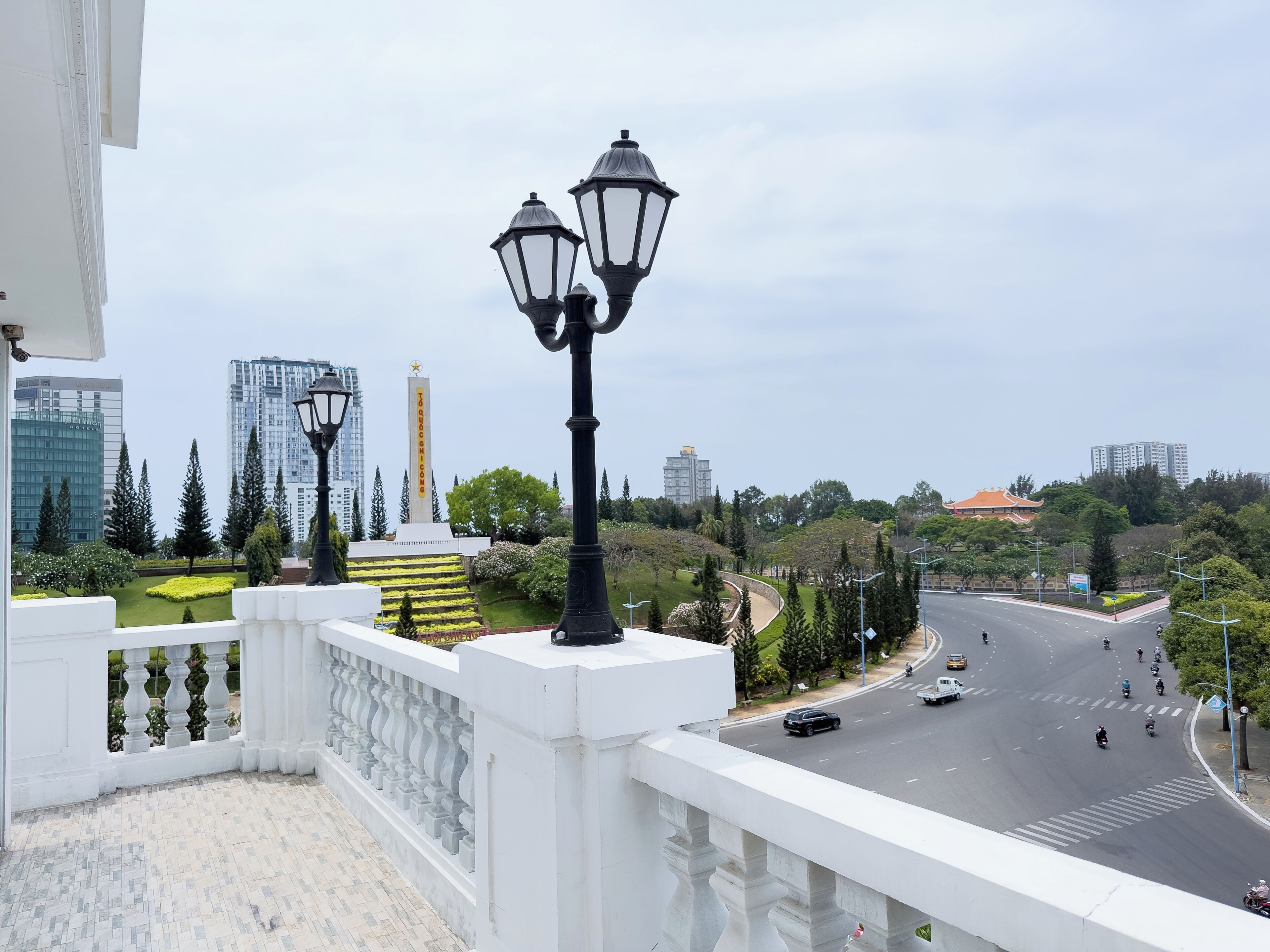 Un balcon offrant une vue sur le paysage urbain, avec des bâtiments et un monument.