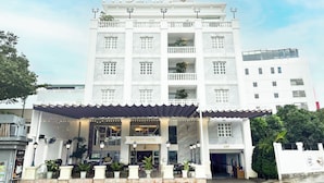 Een hotel met een witte gevel, meerdere balkons en een bord met de tekst 'PHOENIX HOTEL'.