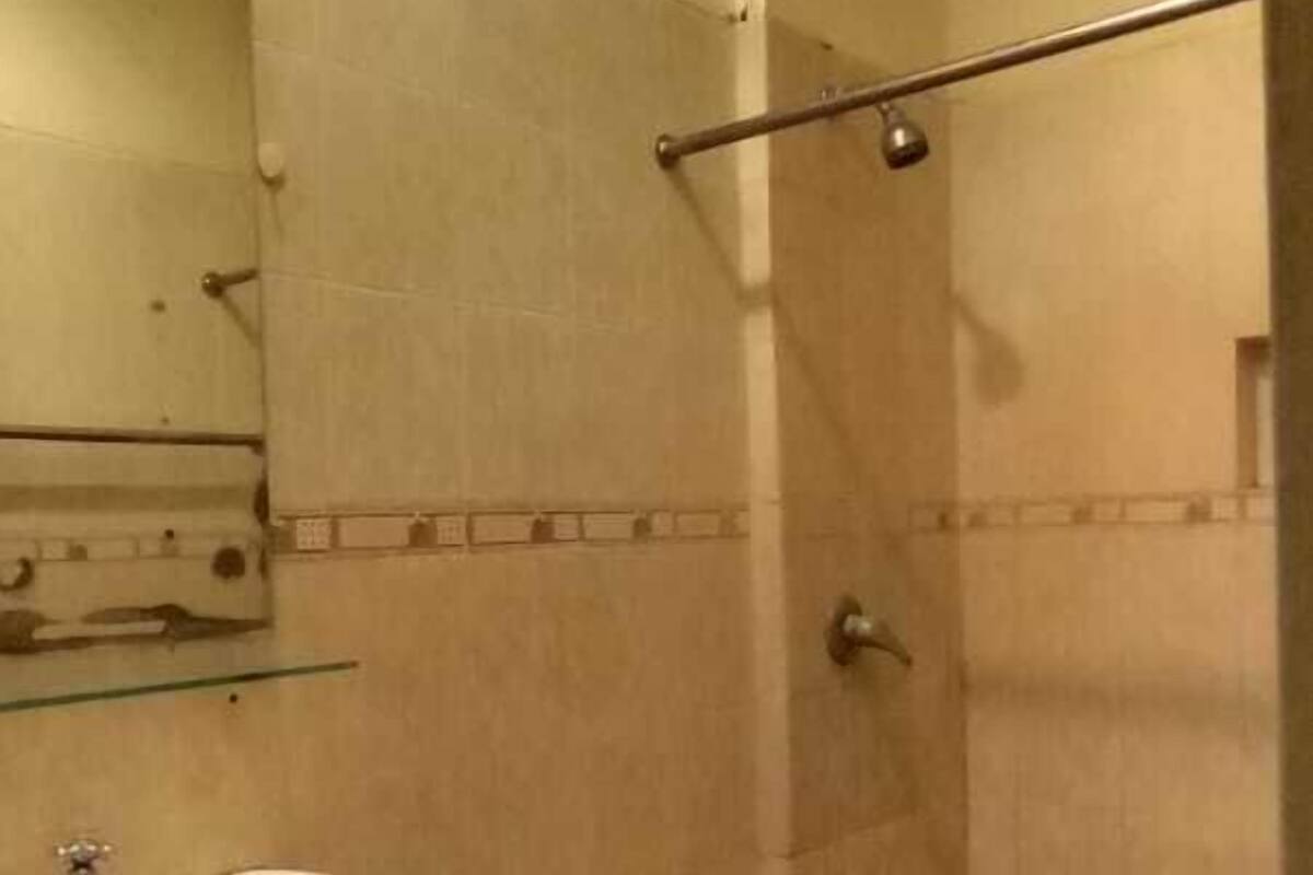 A small bathroom with a toilet, sink, and shower.