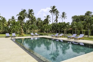 Una piscina al aire libre, sillones reclinables de piscina