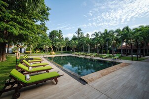 Una piscina al aire libre, sillones reclinables de piscina