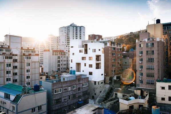 Un immeuble de grande hauteur, doté de nombreux étages et de balcons, entouré d’autres bâtiments.