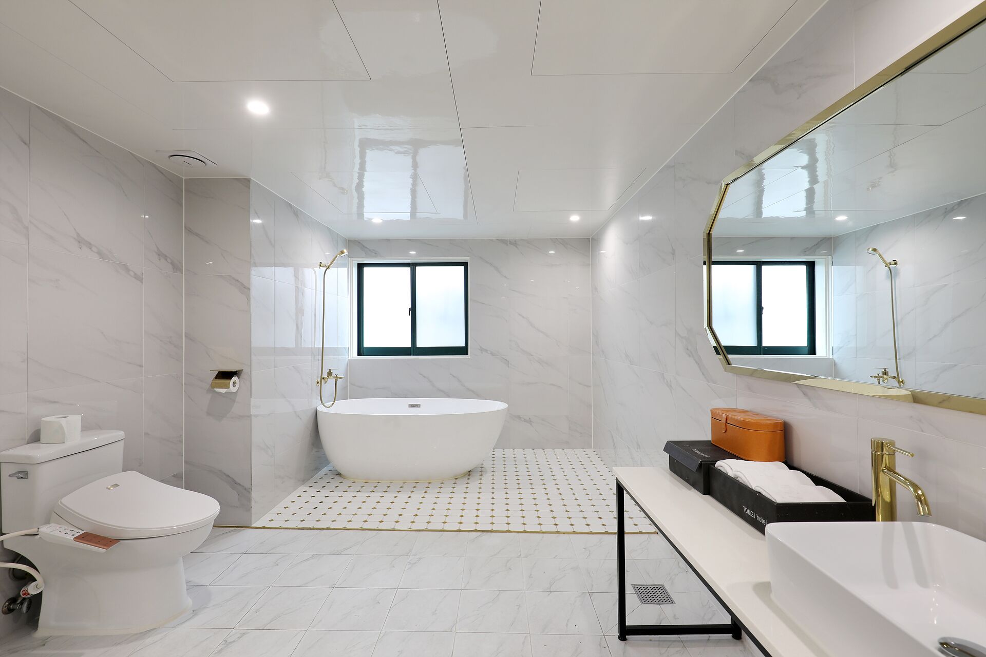 Un baño moderno con una bañera independiente, inodoro y lavamanos.