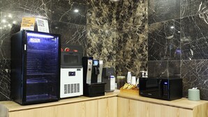 A self-service beverage station with a digital display, a coffee machine, and a microwave. - Hotel Tomgi Jamsil (Seoul)