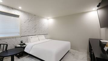 A modern bedroom with a bed, a desk, and a chair.