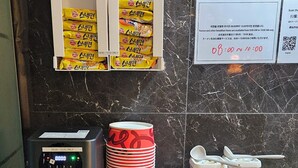 Una barra de desayuno con una cafetera, platos apilados, condimentos y alimentos.