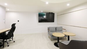 Una habitación de hotel moderna con una cama grande, un escritorio, una silla y una mesita.