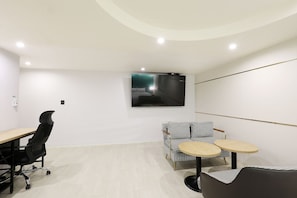 Una habitación de hotel moderna con una cama grande, un escritorio, una silla y una mesita.