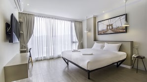 A modern hotel room with a large bed, a desk, and a television. - Hataara Hua Hin (Hua Hin)