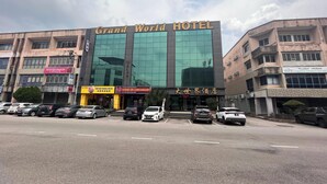 A hotel with a modern facade, multiple floors, and a prominent sign reading "Grand World Hotel". - Capital O 91074 Grand World Hotel (Masai)