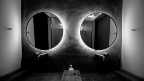 A bathroom with two large, round mirrors and a single sink. - SLEEEP Soho (Hong Kong)