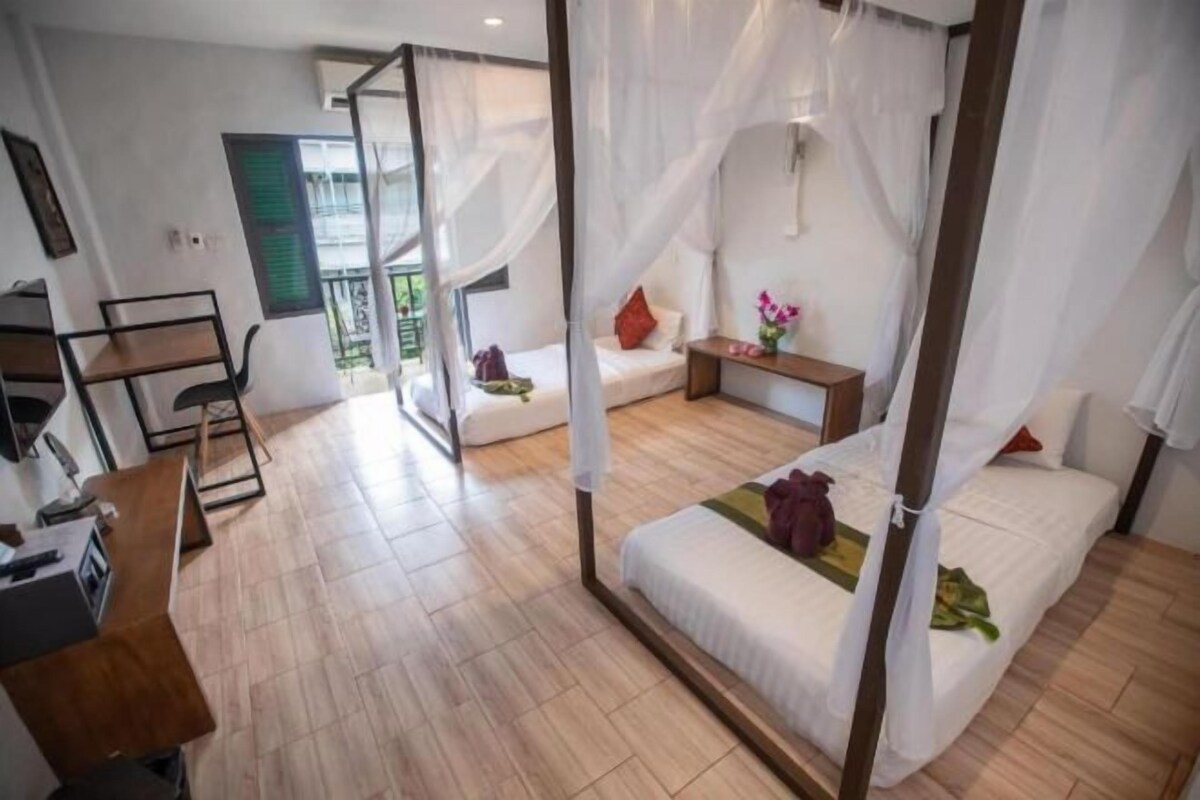Un dormitorio con cama con dosel, un escritorio y una silla.