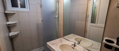 Un bagno con due lavandini, uno specchio e una cabina doccia.
