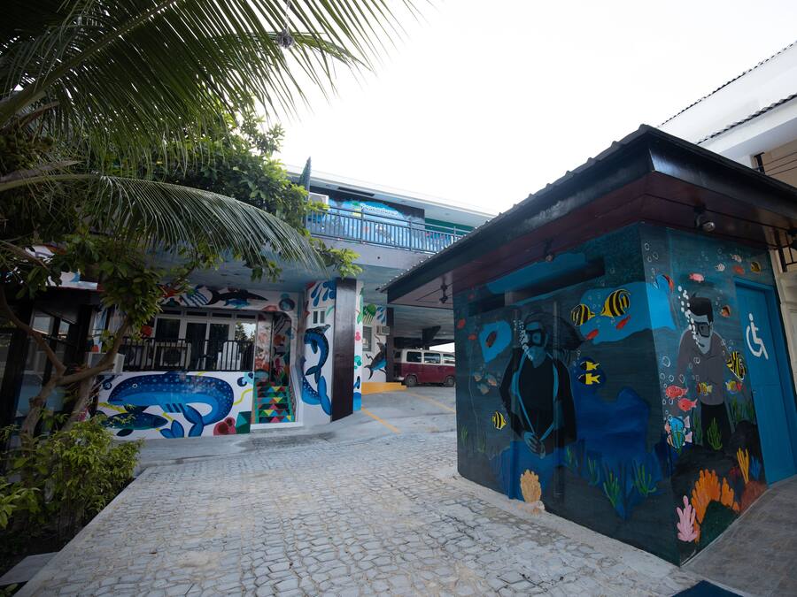 A colorful mural with a diver and marine life on a building facade.