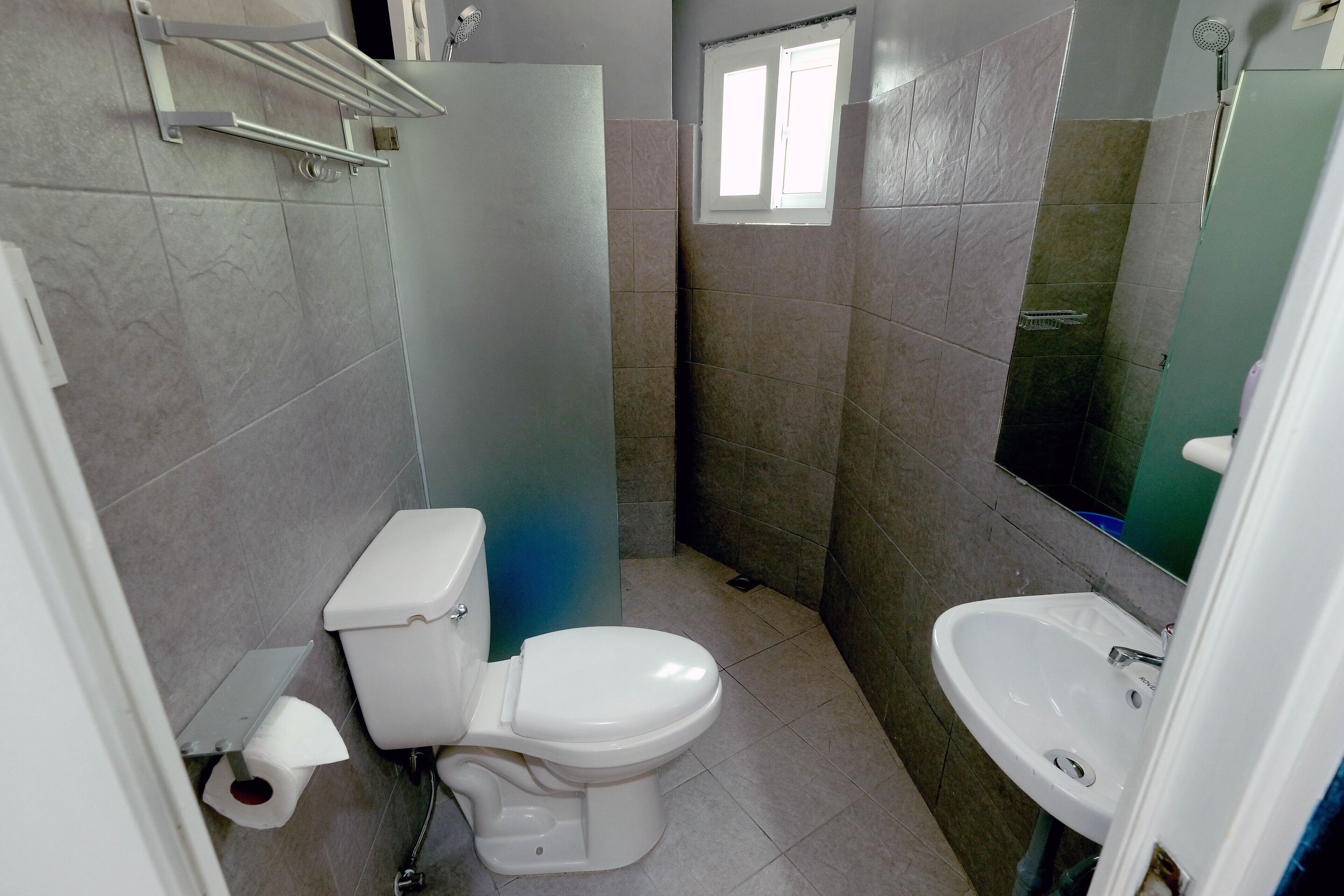 A bathroom with a toilet, sink, and shower.