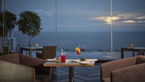 Un comedor con una mesa dispuesta para dos, con vista a un cuerpo de agua.