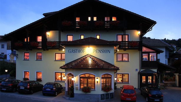 A building with a sign reading "GASTHOF PENSION" with multiple windows and balconies, and several cars parked in front. - Arracher Hof (Arrach)