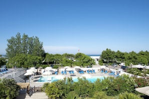 Una piscina al aire libre de temporada, sombrillas