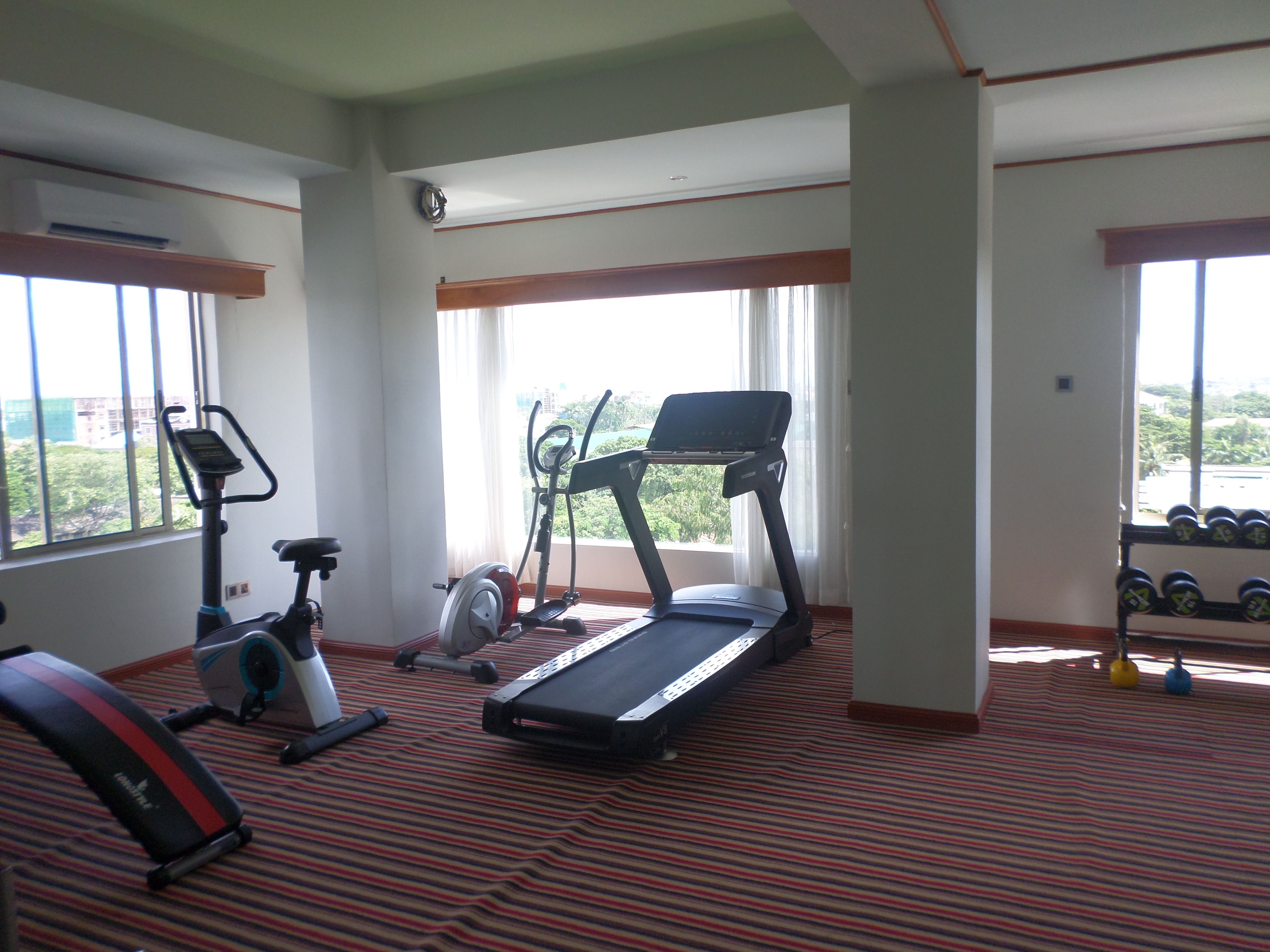 A gym with treadmills, an elliptical, and a stationary bike.