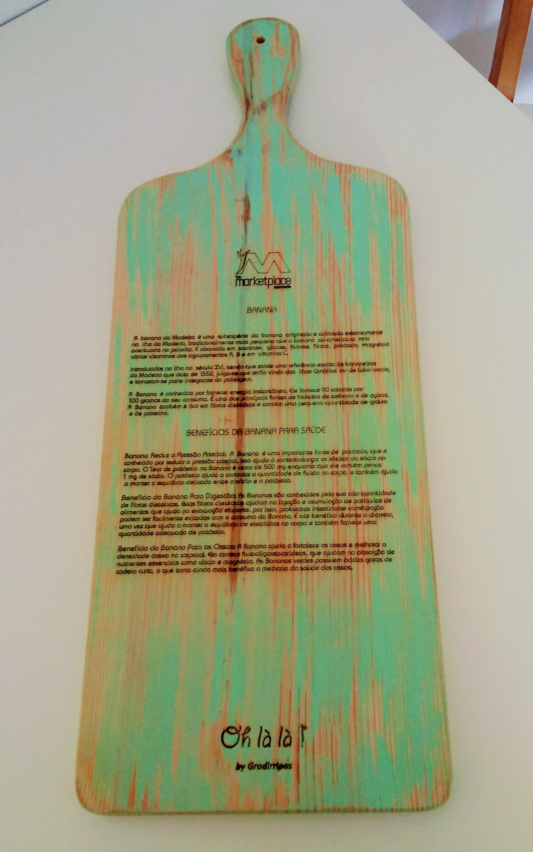 A wooden cutting board with text and a logo, likely used for food preparation.