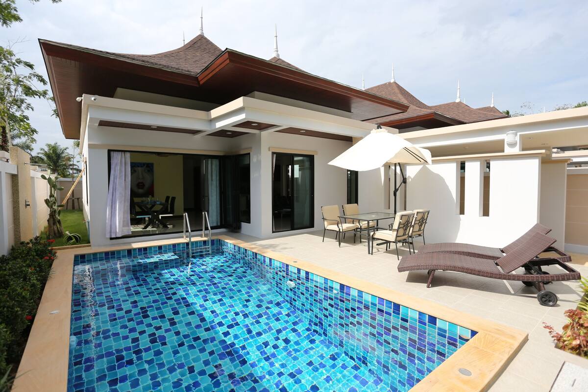 A modern house with a swimming pool, outdoor furniture, and a covered patio area.