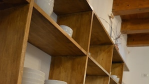 En køkkenbordplade med forskellige spisemøder, herunder skåle med cornflakes og frugt, samt en kaffemaskine.