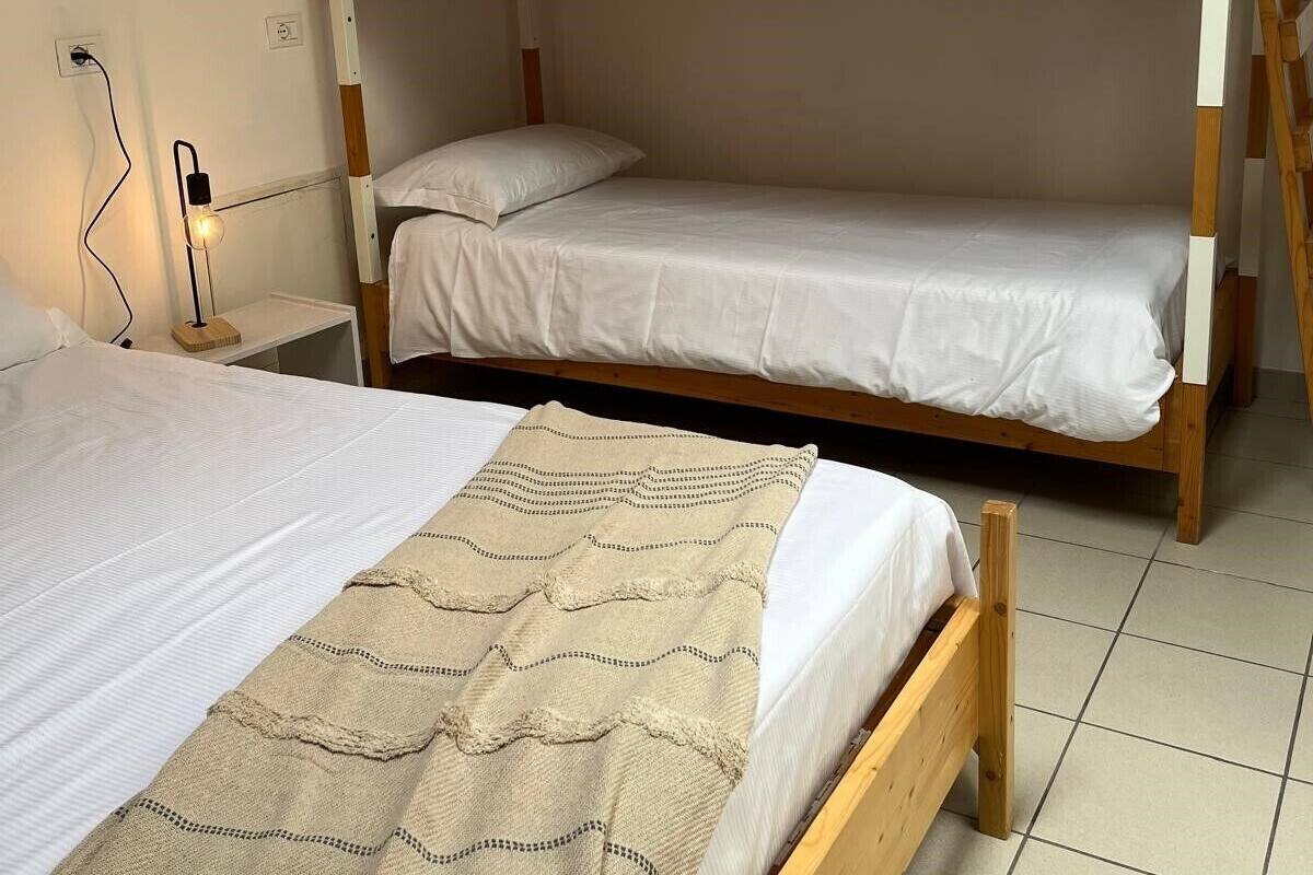 A bunk bed room with a single bed on the left and a bunk bed on the right.