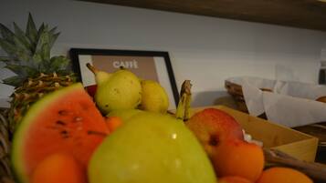 Eine Obstschale mit Ananas, Wassermelone, Birne und Apfel.