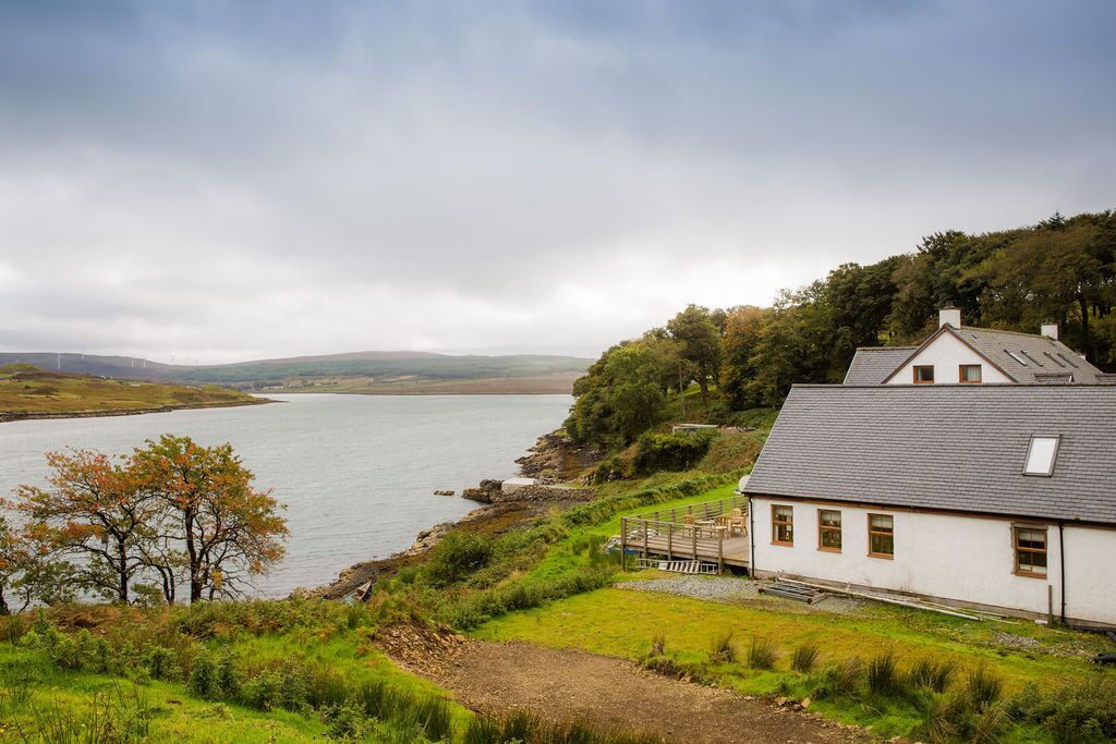 Ein Küstenhaus mit Blick auf das Meer und die Hügel.