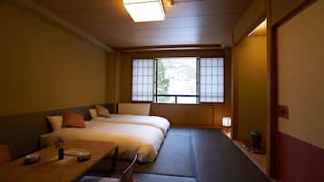 A traditional Japanese room with tatami flooring, a low bed, a table with a vase and bowls, and a window with shoji screens.