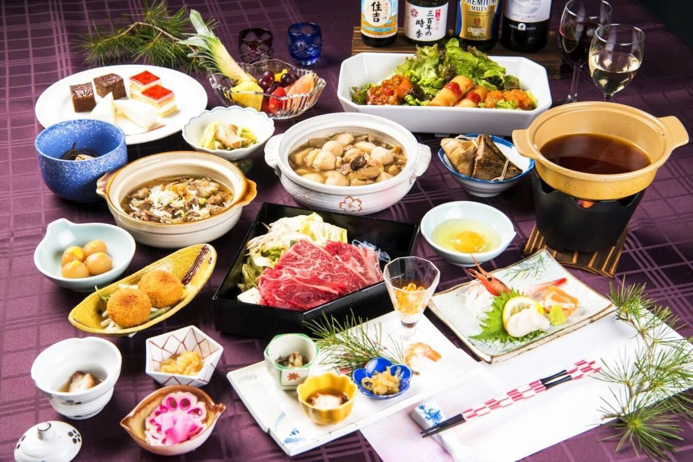 A variety of Japanese dishes, including sushi, sashimi, and a hot pot, arranged on a table with a checkered tablecloth.
