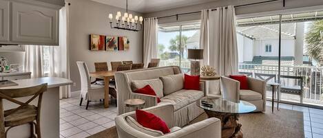 Un salón amplio con sofá, sillas, mesa de comedor y balcón con vistas a los alrededores.