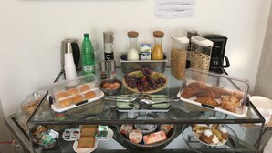 A breakfast buffet with various food items and beverages, including pastries, bread, and condiments. - Atmos Luxe Navigli Hostel & Rooms (Milan)