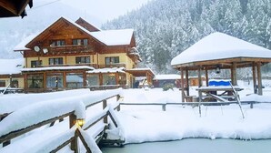 Un chalet en bois à plusieurs niveaux, doté d’un espace extérieur aménagé et abrité.