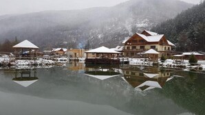 Un chalet au bord du lac comprenant plusieurs cabanes, un bâtiment principal et un quai.