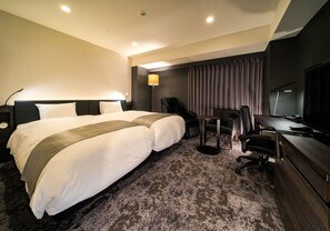 Habitación de hotel con dos camas, un escritorio, una silla, un televisor y un sillón de masaje.