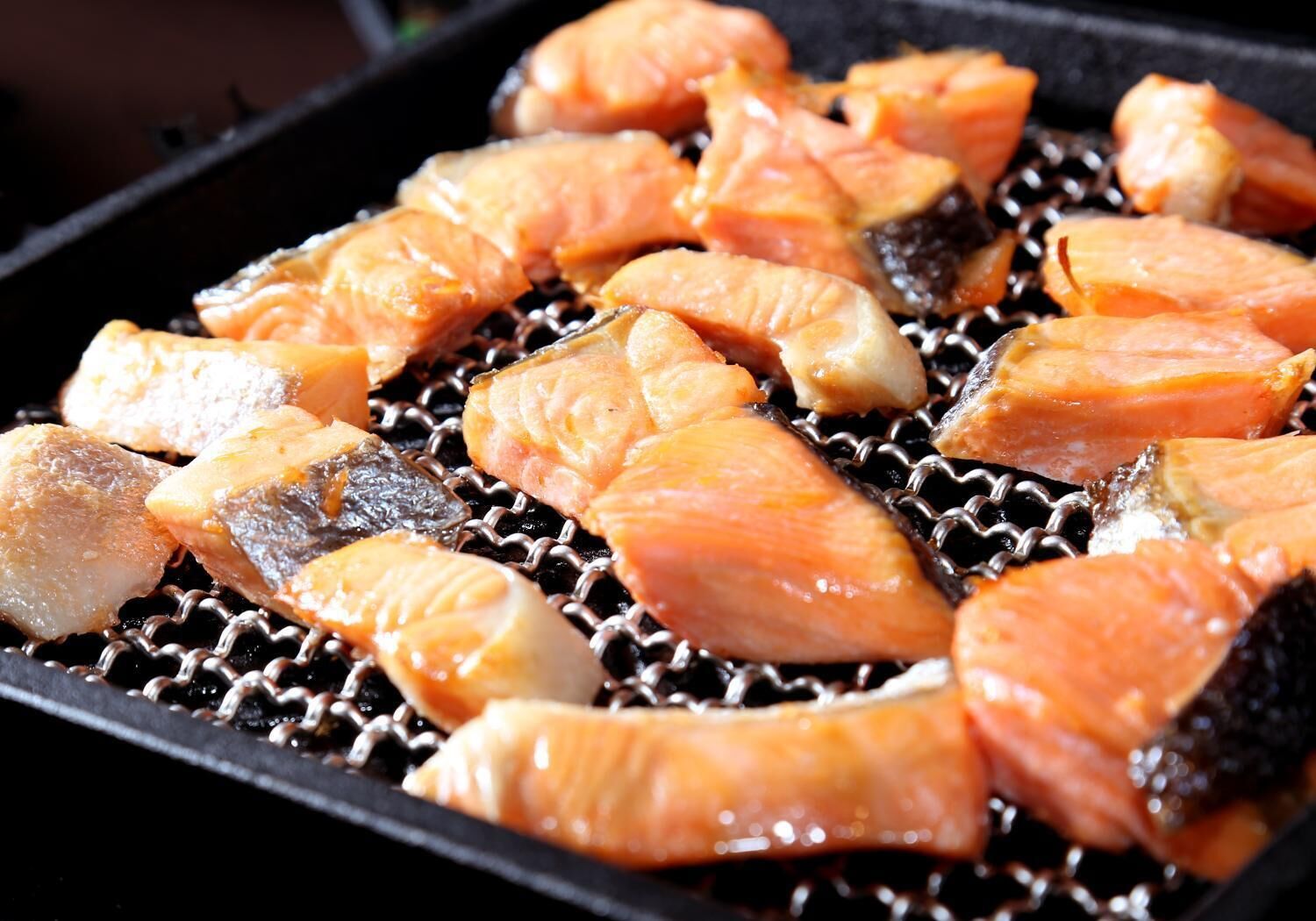 Du saumon est en train de griller sur une grille métallique.