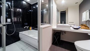 A modern bathroom with a bathtub, a shower, a sink, and a toilet.