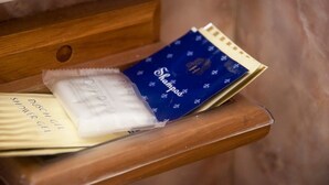 Un estante de madera con un paquete azul y blanco etiquetado 