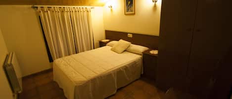 Un dormitorio con cama, mesita de noche y armario.