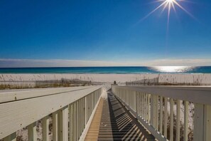 A wooden boardwalk leading to a beach with clear skies and sunlight. - Caribbean Paradise 4 Bedroom Holiday Home by Five Star Properties (Miramar Beach)