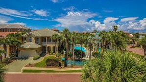 A residential area with houses, a swimming pool, and palm trees. - Casa de Fiesta 5 Bedroom Holiday Home by Five Star Properties (Destin)